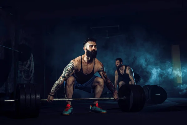 Два м'язистих бородатих татуйованих спортсменів тренування в спортзалі — стокове фото