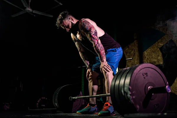 Muskulöser Fitness-Mann bereitet sich darauf vor, in einem modernen Fitnesszentrum eine Langhantel über den Kopf zu heben.. — Stockfoto