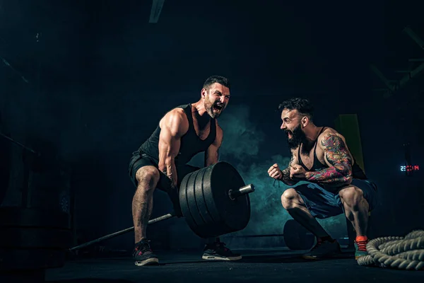 Dois atletas musculosos tatuados treinando no ginásio — Fotografia de Stock