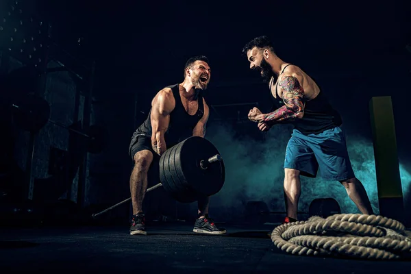 Dois atletas musculosos tatuados treinando no ginásio — Fotografia de Stock