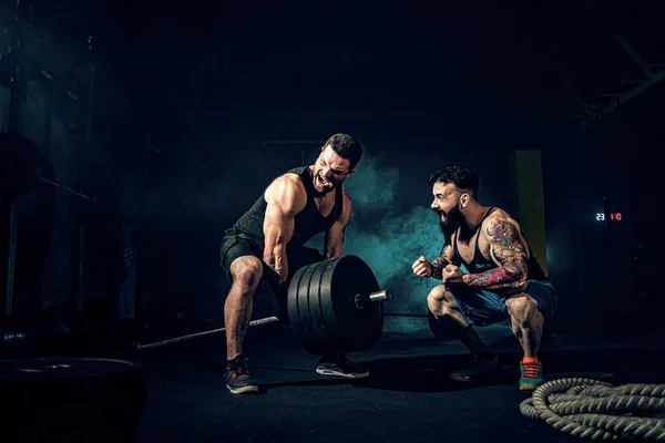 Két izmos szakállas tetovált sportoló edz az edzőteremben. — Stock Fotó