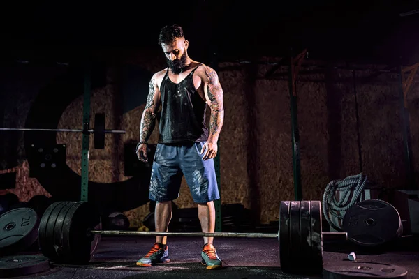 Homem de aptidão muscular que se prepara para deadlift de um sino no centro de fitness moderno. Treinamento funcional. — Fotografia de Stock