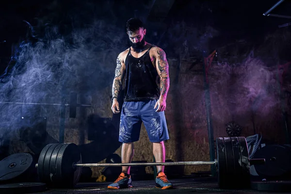 Homem de aptidão muscular que se prepara para deadlift de um sino no centro de fitness moderno. Treinamento funcional. — Fotografia de Stock