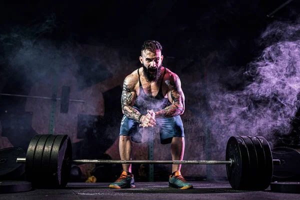 Homem de aptidão muscular que se prepara para deadlift de um sino no centro de fitness moderno. Treinamento funcional. — Fotografia de Stock