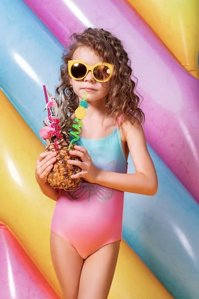 Piękna dziewczyna w kolorowym stroju kąpielowym i okularach przeciwsłonecznych trzymając koktajl ananasowy — Zdjęcie stockowe