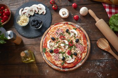 Ahşap tahta üzerinde ev yapımı pizza, domates ve salam, mantar, eski ahşap masada Italyan tarzı, üst görünüm