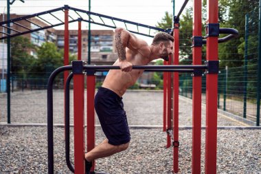 Açık sokak spor salonunda düzensiz barlarda şınav yapıyor Güçlü kaslı adam