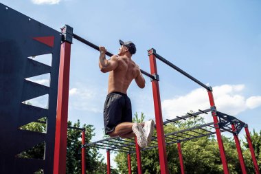 Acımasız atletik adam bir crossbar üzerinde pull-up egzersizleri yapma.