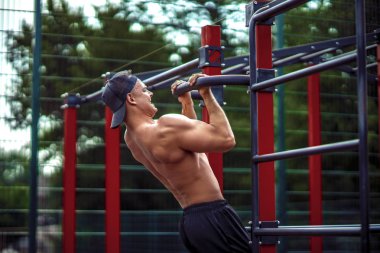 Acımasız atletik adam bir crossbar üzerinde pull-up egzersizleri yapma.