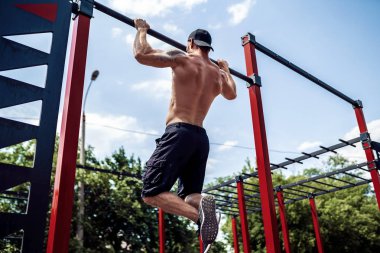 Acımasız atletik adam bir crossbar üzerinde pull-up egzersizleri yapma.