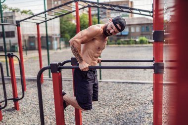 Açık sokak spor salonunda düzensiz barlarda şınav yapıyor Güçlü kaslı adam