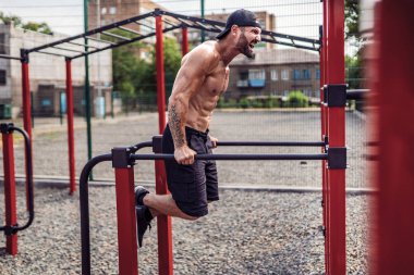 Açık sokak spor salonunda düzensiz barlarda şınav yapıyor Güçlü kaslı adam