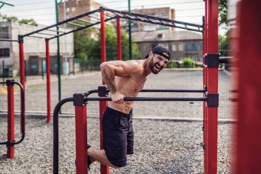 Açık sokak spor salonunda düzensiz barlarda şınav yapıyor Güçlü kaslı adam