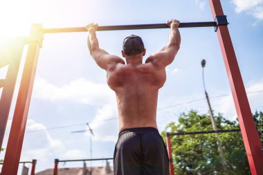 Acımasız atletik adam bir crossbar üzerinde pull-up egzersizleri yapma.