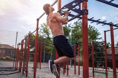Acımasız atletik adam bir crossbar üzerinde pull-up egzersizleri yapma.