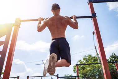 Acımasız atletik adam bir crossbar üzerinde pull-up egzersizleri yapma.