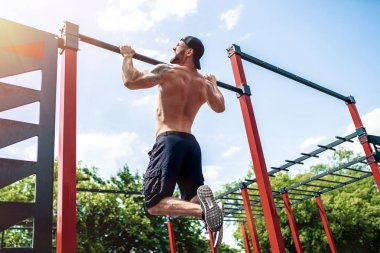 Acımasız atletik adam bir crossbar üzerinde pull-up egzersizleri yapma.