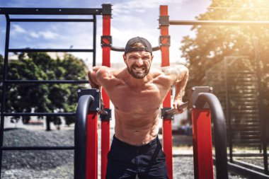 Açık sokak spor salonunda düzensiz barlarda şınav yapıyor Güçlü kaslı adam