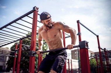 Acımasız atletik adam bir crossbar üzerinde pull-up egzersizleri yapma.