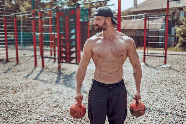 Homem atlético trabalhando com um kettlebell no pátio do ginásio de rua. Força e motivação . — Fotografia de Stock