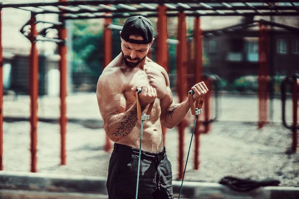 Homem de fitness exercitando com banda de alongamento no ginásio ao ar livre . — Fotografia de Stock