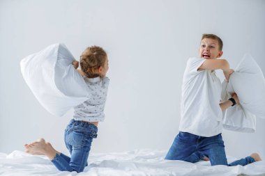 Yaramaz ikizler kız ve erkek dostu mücadele yatak odasında yatakta bir yastık mücadele sahneledi.