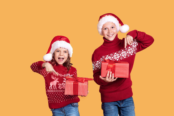 Happy children holding red gift boxes