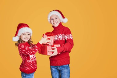 Kırmızı hediye kutularını tutan mutlu çocuklar.