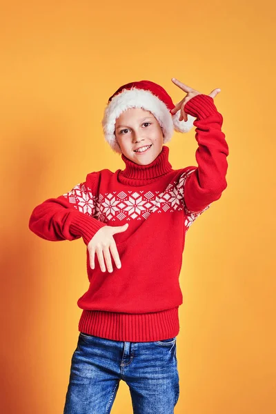 Niño en Santa sombrero mostrando pulgares hacia arriba en amarillo —  Fotos de Stock