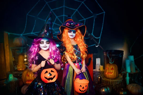 Dos lindas hermanas divertidas celebran la fiesta. Niños alegres en trajes de carnaval listos para Halloween . — Foto de Stock