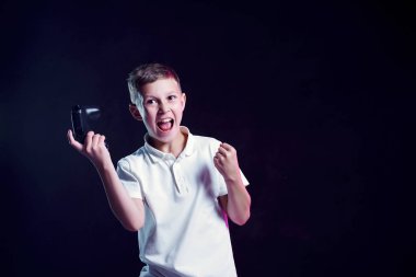 Siyah arka plan üzerinde video oyunu kazandıktan sonra sevinç için bağıran açık ağız ve joystick ile Mutlu çocuk