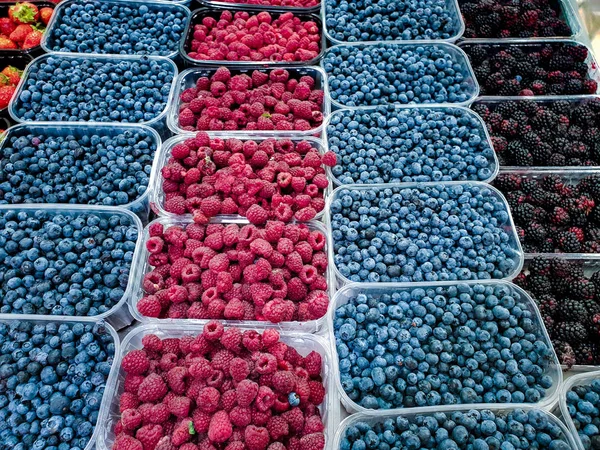 Varias bayas frescas Frutas en bandejas de plástico en el mercado de alimentos puesto — Foto de Stock