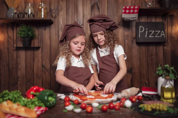 Veselé sestry spolu vaří pizzu — Stock fotografie