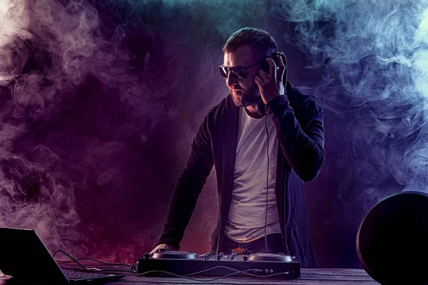 Dj masculino de moda posando contra la consola de mezcla — Foto de Stock