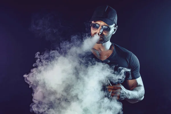 Men with beard in sunglasses vaping and releases a cloud of vapor — Stock Photo, Image