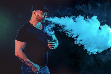 Güneş gözlüklü vahşi sakallı adam buharlaşıyor ve bir duman bulutu salıyor..