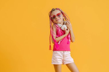 Parlak elbiseli, kulaklıklı ve parlak saçlı çılgın, modaya uygun DJ kız. Disko, parti