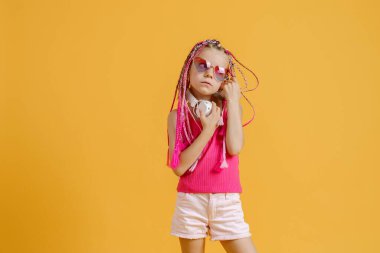 Parlak elbiseli, kulaklıklı ve parlak saçlı çılgın, modaya uygun DJ kız. Disko, parti