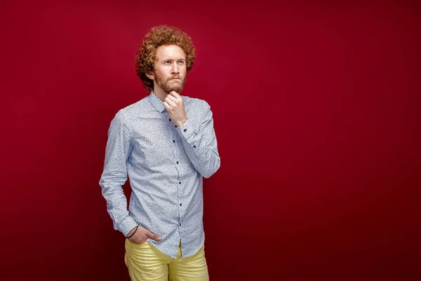 Joven hombre guapo de vacaciones con camisa de verano sobre fondo rojo aislado con la mano en la barbilla pensando en la pregunta, la expresión pensativa. Cara pensativa. Concepto de duda. — Foto de Stock