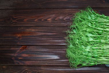 Eski ahşap masada kesilmiş mikro yeşil bezelye filizi. Vejetaryen ve sağlıklı beslenme konsepti. Büyüyen filizler