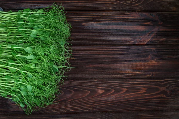 Brotes de guisantes microverdes cortados en una vieja mesa de madera. Concepto de alimentación vegana y saludable. Crecimiento de brotes — Foto de Stock