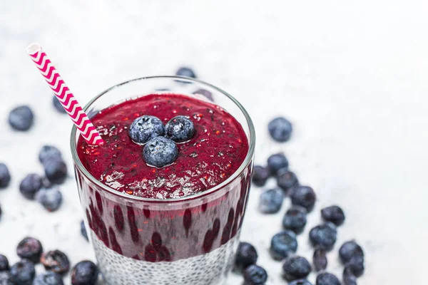 Gezond ontbijt of ochtendsnack met chia zaden en bosbessen op witte stenen achtergrond, vegetarisch voedsel, dieet en gezondheidsconcept — Stockfoto