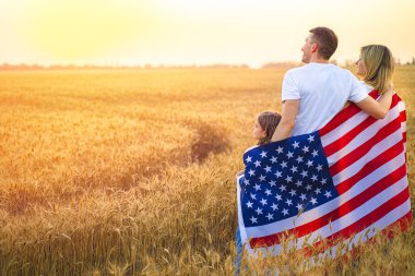 Tanımlanamayan mutlu bir ailenin Amerika ve Amerikan bayrağıyla arka planda buluşması.