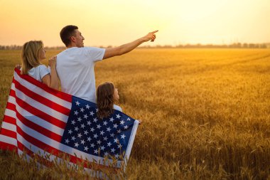 Tanımlanamayan mutlu bir ailenin Amerika ve Amerikan bayrağıyla arka planda buluşması.
