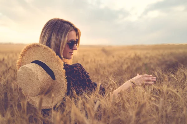 Жінка в одязі тваринного паперу, солом'яний капелюх перед сонцем в середині поля пшениці з задоволенням, насолоджуючись літніми святами. — стокове фото
