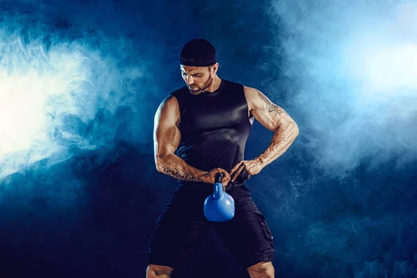 Aggressiver bärtiger muskulöser Bodybuilder, der mit der Kettlebell Übungen für den Bizeps macht. Studioaufnahme — Stockfoto