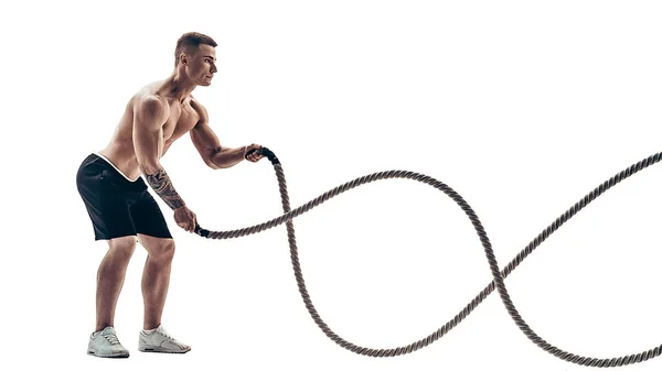 Hombre musculoso atractivo haciendo ejercicio con cuerdas pesadas. Foto de un hombre guapo en ropa deportiva aislado sobre fondo blanco — Foto de Stock