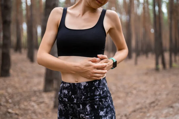 Side stitch woman runner side cramps after running. Jogging woman with stomach side pain after jogging work out. Female athlete. Sport, health and people concept — Stock Photo, Image