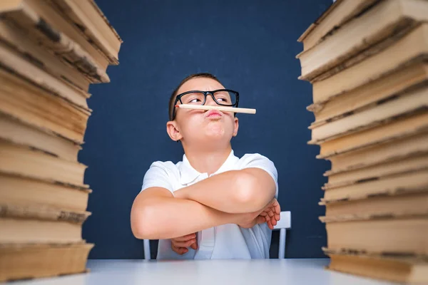 Klug aussehender Junge, Bleistift im Mund, wegschauen und nachdenken. Konzentrationsproblem erforschen, studieren und lösen — Stockfoto