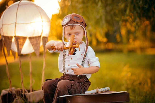 A little boy dreams of becoming a pilot. Vintage aviation hat — Stock Photo, Image